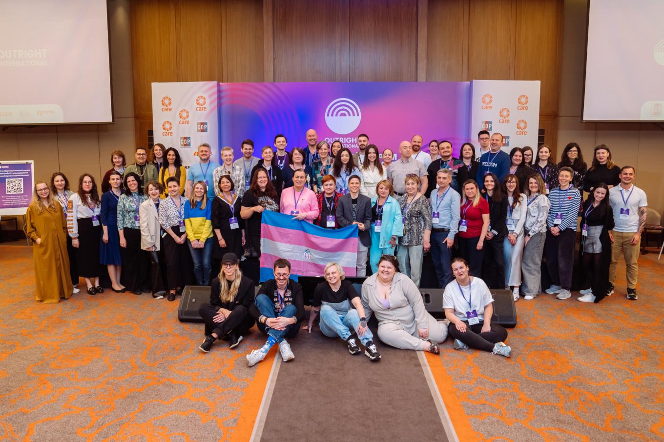 Participants of Ukraine's National Forum stand together in front of purple backdrop